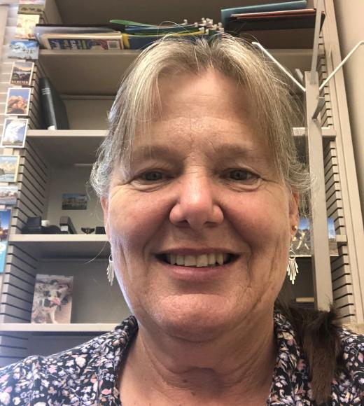 A portrait of a woman in front of a bookshelf