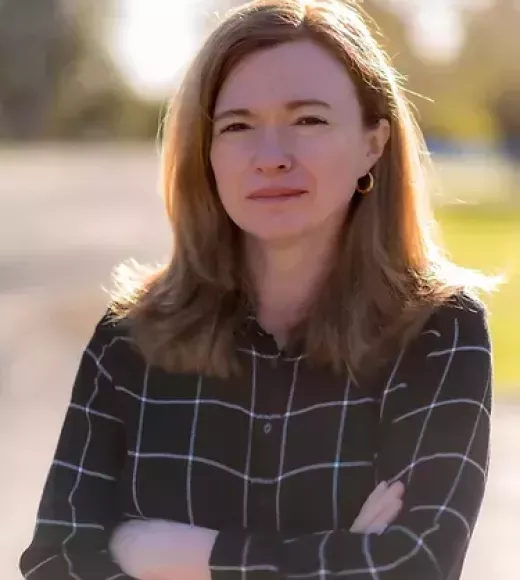 A photo of a woman with her arms crossed.