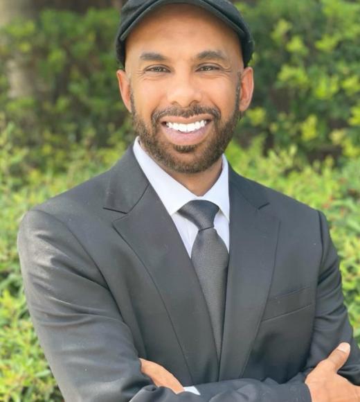 A man wearing a suit and tie and flat cap
