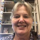 A portrait of a woman in front of a bookshelf