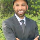 A man wearing a suit and tie and flat cap